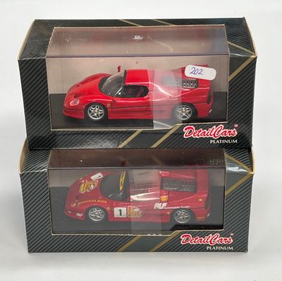 une petite voiture rouge dans une boîte sur une surface blanche