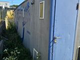 a blue portable toilet sitting in the middle of a yard