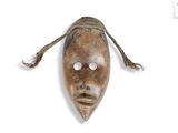 an image of a wooden mask hanging on a wall