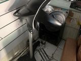 a black grill in the corner of a room with a brown chair