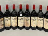 six bottles of red wine lined up in a row