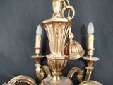 a gold colored chandelier with three lights on it