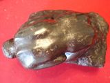 a chocolate bear that is sitting on a red surface