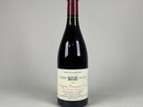 une bouteille de vin rouge posée sur une table blanche