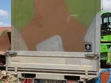 graffiti on the back of a truck parked in a dirt lot