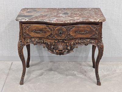 an old wooden table with a marble top sitting on a tile floor