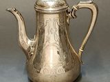 silver plated coffee pot with ornate design on top of it