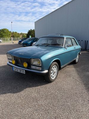 une voiture bleue garée dans un parking à côté d'un bâtiment