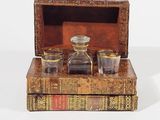 three glasses and a bottle sitting on top of a box