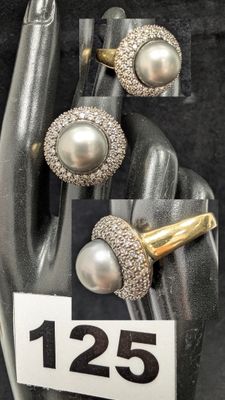 un présentoir sur lequel sont posés une bague et une paire de boucles d'oreilles