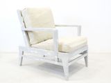 a white chair with a cushion on it in a room