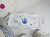 a white table topped with blue and pink plates and bowls