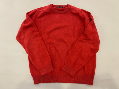 a red sweater sitting on top of a white table
