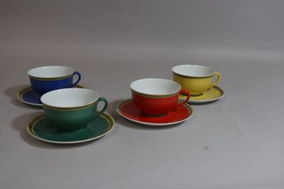 four cups and saucers are lined up on a white surface