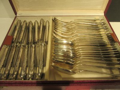 beaucoup de couverts dans une boîte posée sur la table