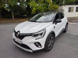une voiture blanche garée sur le bord de la route, devant une maison