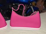 pair of pink tennis shoes sitting on top of a table next to a motorcycle