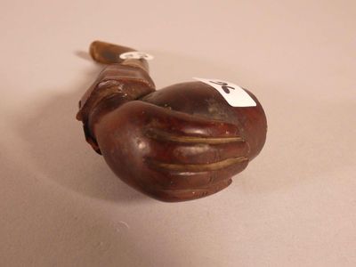 a small wooden pipe with a white tag on it