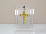 une croix jaune exposée dans une vitrine transparente