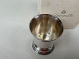 a silver cup sitting on a table next to a box