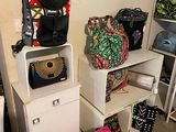 many bags and purses stacked on top of each other