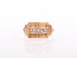 a close up of a gold and diamond ring on a white surface