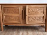 a wooden cabinet that has carvings on the doors