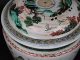 a close up of a vase with a lid on a table