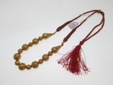 collier en perles dorées avec un pompon rouge et un pompon rouge
