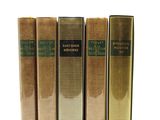trois livres sont alignés sur une surface blanche, à côté d'une brosse à dents