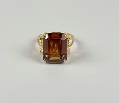 Gros plan sur une bague contenant une pierre orange