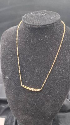 un collier en or sur un mannequin, sur fond noir