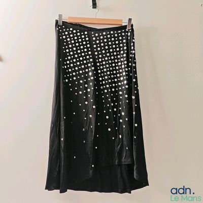 a black skirt with white dots on it hanging on a wall