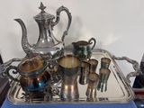 un plateau en argent sur lequel sont posés une théière et des tasses en argent