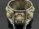 gros plan d'un bracelet en argent sur une surface noire