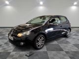 la voiture noire est garée sur un sol en damier dans le garage