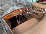 a dashboard and steering wheel of a car in a parking lot