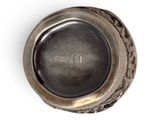 a silver vase with a black lid on a white surface