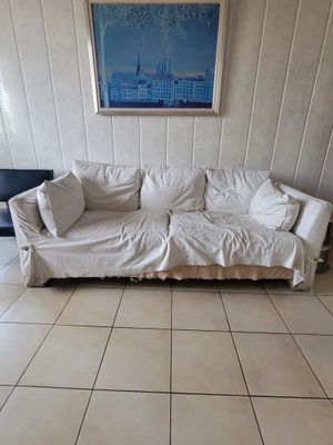 a white couch in a living room with a picture on the wall