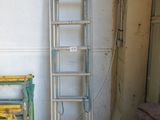 une échelle appuyée contre un mur, à côté d'une chaise