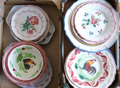 Plusieurs assiettes et bols se trouvent dans une boîte en carton posée sur une table