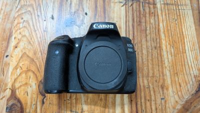 un appareil photo Canon posé sur une table en bois