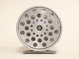 a metal object with holes on it on a white surface