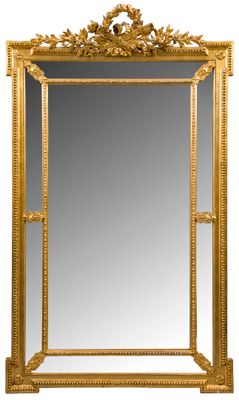 un grand miroir dans un cadre doré, orné d'un motif décoratif