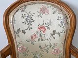 a wooden chair with a floral upholstered back