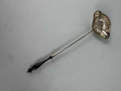 a silver spoon with a black handle on a white surface