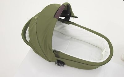 un sac vert contenant un sac blanc, posé sur une surface blanche