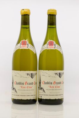 deux bouteilles de vin blanc posées l'une à côté de l'autre sur une surface blanche