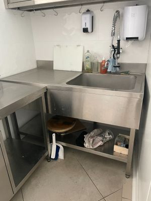 un évier en acier inoxydable dans une cuisine, à côté d'un plan de travail