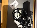 two laptops on a table with wires and a charger